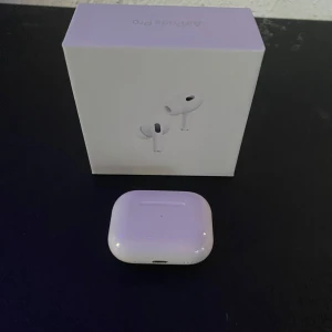 AirPods Pro - Snygga och populära AirPods Pro från Apple, komplett med originalförpackning. Trådlösa hörlurar med aktiv brusreducering och laddningsetui. Produkten ser ut att vara i gott skick utan synliga skador eller slitage. Perfekt för musik, samtal och träning.