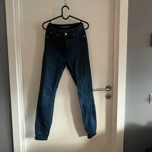 Mörkblå skinny jeans från Amisu - Säljer ett par mörkblå skinny jeans från Amisu med hög midja. Jeansen har klassisk femficksdesign, knapp och dragkedja fram samt smal passform hela vägen ner. 