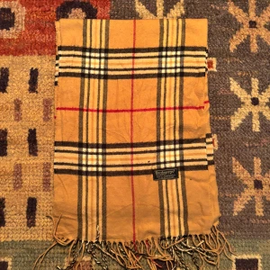 Vintage Burberry halsduk  - -Riktigt bra skick. Nypris på dessa ligger på runt 5000kr, vilket gör detta till ett sjukt bra pris! Halsduken är gjord i Lamull, och är perfekt inför hösten och den kommande vintern. Anledningen till att det står ”Burberry’s” och inte ”Burberry” på lappen är eftersom halsduken är från några år tillbaka, innan de bytte namn! Om du har någon fråga är det bara att skriva till mig. /elgnce (5)