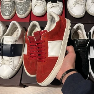 Valentino Flycrews - Hej och välkommen! Säljer dessa Röda och vita Flycrewsen som är i ett gott skick. Smått slipade och 4 nitar borta totalt. Mockan är i ett mycket fint skick och inga defekter förekommer på skorna. Storlek 39,5. Box, skorna, 2st dustbags, kuvert med kort och extrasnören medföljer! Skriv vid minsta intresse av köp! Mvh DC 🔹