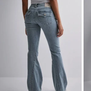True religon jeans  - Snygga ljusblå jeans med bootcut-modell och klassisk femficksdesign. Jeansen har en låg midja och är tillverkade i mjukt denimtyg som ger en skön passform. Modellen är den populära joey low Rise flare, nypris 1300kr💕nyskick!