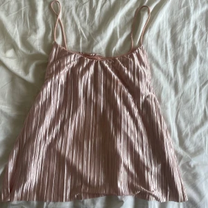 Ljusrosa festtopp - Säljer denna super fina ljusrosa linnetopp med tunna axelband och plisserad struktur. Perfekt till fest