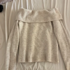 Beige offshoulder stickad tröja Gina Tricot - Supermysig beige stickad tröja från Gina Tricot med bred ribbad kant upptill som sitter offshoulder. Tröjan har långärmade ärmar och ribbade muddar vid ärmslut och nederkant.