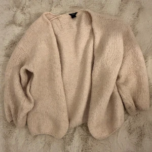 Beige stickad kofta från Lindex - Mysig och oversized beige stickad kofta från Lindex. Koftan har en öppen front utan knappar och är långärmad,  den är lite nopprig men går att ta bort med en noppermarskin 🥰