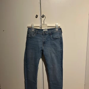 Blå jeans  - Snygga blå jeans klassisk femficksdesign passning. Jeansen har en ljus tvätt och raka ben, samt en läderpatch med logga bak i midjan. Perfekta för dig som gillar stilrena och bekväma jeans. Märket är o känt. Inte från Jack and Jones!