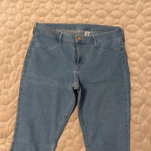 Skinny jeans i ljusblå denim från Denim - Snygga skinny jeans i ljusblå denim från Denim. Modellen har regular midja och ankellängd, vilket ger en fräsch och modern look. Klassisk femficksdesign och bekvämt stretchigt material som sitter tajt hela vägen ner. (M/L storlek)