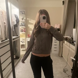 Brun kofta från H&M i bomull - Säljer en brun kofta från H&M i mjuk bomull. Koftan har rund halsringning, långa ärmar och knäppning framtill med matchande knappar. Enkel och stilren modell som är lätt att matcha till olika outfits.