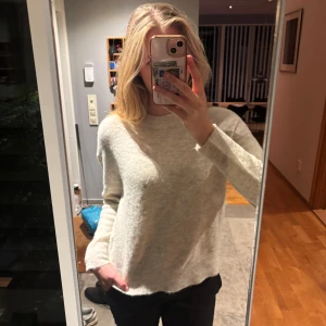 Alpacka Merino stickad tröja - Mysig ljusbeige stickad tröja från Samsøe Samsøe med rund hals och lång ärm. Blandning av alpacka och merino, hållbara material som ej nopprar!