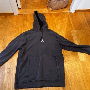 Mörkgrå hoodie från Jordan - Säljer en mörkgrå hoodie från Jordan med klassisk Jumpman-logga på bröstet. Tröjan har huva med snörning, stor magficka och långa ärmar. Perfekt för chill dagar eller när du vill ha en sportig look.