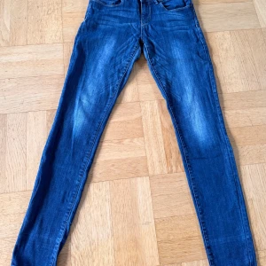 Esprit skinny jeans blå 30/34 - Säljer ett par blå Esprit skinny jeans i storlek 30/34. Jeansen har klassisk femficksdesign, snygga ljusa slitningar och dekorativa sömmar på bakfickorna. Modellen är smal och sitter tajt längs benen. Perfekt för dig som gillar en modern och stilren look.