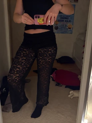 Svarta vida spetsbyxor - Säljer ett par supersnygga svarta byxor i  spets med blommigt mönster. Byxorna har låg midja och vida ben✨ De är köpta från en tjej på Vinted för ca 400kr men tyvärr var det för korta för mig.. (är ca 165cm). Jag har använt de 1 gång och den tidigare ägaren använde de ett fåtal gånger! Vet ej vilket märke det är och pris kan diskuteras!🥰