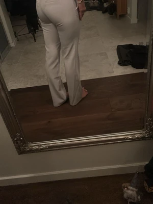 Beige kostymbyxor med straight/bootcut fit - Bikbok populära kostymbyxor! beige kostymbyxor med rak/bootcut passform och klassisk midja. Byxorna har pressveck och fickor fram, vilket ger en stilren och clean look. Perfekta för dig som gillar en enkel och fräsch stil. Materialet känns mjukt och har en lätt stretch.