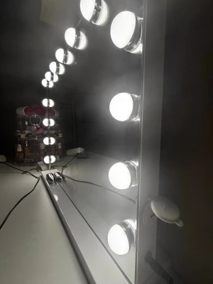 Sminkspegel med LED-lampor Bright Beauty - Stor sminkspegel med 15 starka LED-lampor runt kanten som ger perfekt ljus för att lägga smink. Spegeln har en vit ram och touch-knapp med blå ring för att justera belysningen. Snygg och modern design som passar på sminkbordet. Och har tre olika ljus styrkor 