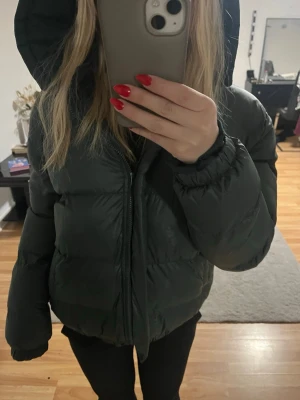 Svart pufferjacka med huva - Säljwr denna snygga jackan från Design By Amor, inte använd