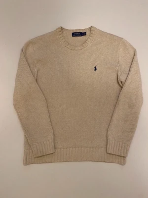 Beige polo Ralph Lauren stickad tröja - Beige grov stickad polo Ralph Lauren tröja //  Storlek M //  Längd 69cm  Bredd längst ner 48cm  Armlängd 62cm  Bredd mellan axlarna 47cm Mycket bra skick //  Skriv vid minsta fråga eller fundering💯🤝