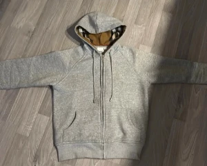 Grå Burberry hoodie  - Säljer denna helt nya burberry hoodien med rutigt tryck i luvan. Riktigt fet tröja att ha nu under vintern och våren. Säljer för att den var för liten när jag köpte och inte hade orken att skicka tillbaka. Behöver pengar så säljer fort. Helt ny utan prislapp 💯💯💯