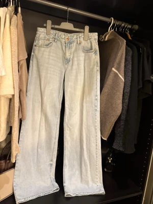 Ljusblå wide jeans från Stradivarius - Säljer ett par ljusblå jeans från Stradivarius, modell D91. De har en klassisk femficksdesign, raka och vida ben samt låg midja. Jeansen är tillverkade i bomull och har en snygg, avslappnad passform som är perfekt till en trendig vardagslook.