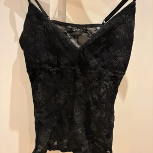 Svart fest topp  - Den är i spets med lite glitter, och knytsnören på sidorna som cool detalj.