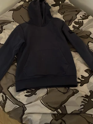 Mörkblå Stone Island Hoodie  - En mörkblå Stone Island hoodie i bra skick förutom en knapp som jag sytt på badgen själv annars bra skick skriv om ni har några frågor 