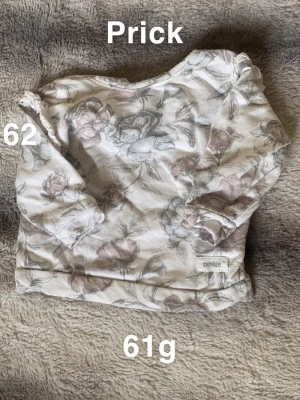 Blommig långärmad tjocktröja från Newbie - Säljer en söt långärmad tjocktröja från Newbie i storlek 62. Tjocktröjan är vit med blommigt mönster. Den har rund hals. Perfekt för små barn som vill vara både bekväma och fina.🌸 Liten fläck. Storlek 62