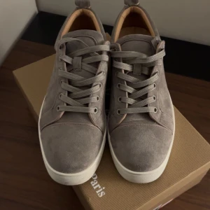 Gråa Loubs  - Säljer ett par gråa lubs. Låda,kartong och påse kommer med. Det finns tecken på användning men inga slitningar på mockan och heller inga hål. Tar emot byten.