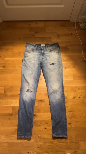 Jack and Jones jeans med slitningar - Säljer mina riktigt snygga Jack and Jones jeans med slitningar då jag inte använder dom längre, jeansen har riktigt snygg tvätt och snygga slitningar. Dom är i fint skick och har inga defekter. Priset går att diskuteras! Storlek 28:32 men passar även w29-w30. 