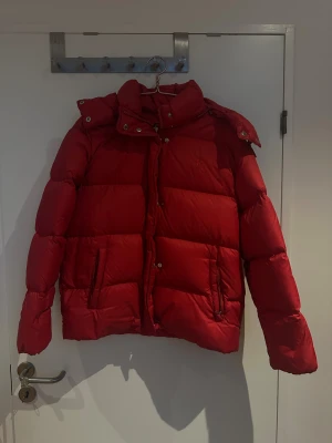 Röd pufferjacka från Polo Ralph Lauren - Säljer min snygga vinterjacka från  Ralph lauren  då den tyvärr inte kommer till användning längre. Fodret är 100% dun så den är riktigt varmt på vintern. I mycket god skick 