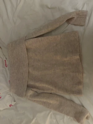 Off-shoulders tröja - Säljer denna off-shoulder tröja som är beige och perfekt för vintern! Delen längst upp sitter inte fast utan man viker ner den själv.