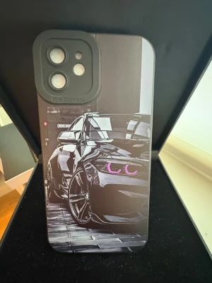 iPhone 12 Skal med Bilmotiv - Snyggt och tåligt skal för iPhone 12 med unikt bilmotiv. Skyddar din mobil mot repor och stötar. Skalet är i nyskick och har ett coolt designtryck med sportbil. Passar perfekt för bilentusiaster som vill ge sin iPhone ett personligt utseende.