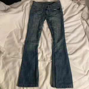 Sjukt snygga blå bootcut jeans - Snygga blå bootcut jeans med låg midja och femficksdesign. De är omsydda till bootcut så det finns en söm men den är inte synlig. Har några små slitningar men absolut inte något man tänker på. Jag är 165 och längden funkar bra. Inte mina bilder.🩷🩷
