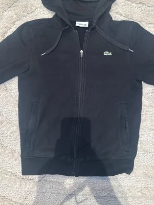 Svart Lacoste kofta - Snyggaste koftan som finns allting sitter perfekt och det finns inga problem alls. Det är storlek XS men den sitter som en S