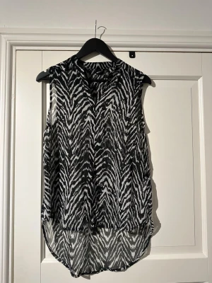 Zebramönstrad blus från GinaTricot - Zebramönstrad blus utan ärm i storlek 36 från Gina Tricot. Knappar framtill. Längre i bak.