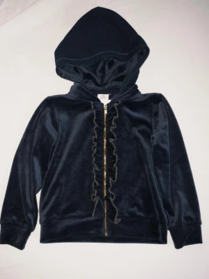 Mörkblå velourjacka - En mjuk och skön huvtröja i mörkblå velour från svenska Polarn O. Pyret. Enligt etiketten är det storlek 104 (3–4 år).