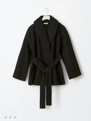 Svart kappa från Gina tricot med bälte - Snygg svart jacka med bred krage och knytskärp i midjan. Perfekt för kallare väder men också till våren. Nypris är 699kr men jag säljer för 499 då kappan är i jätte bra skick, utan några defekter, fläckar osv. Priset kan diskuteras