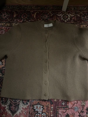 Beige stickad kortärmad kofta  - Säljer en kortärmad kofta köpt från Ullared, använd fåtal gånger 