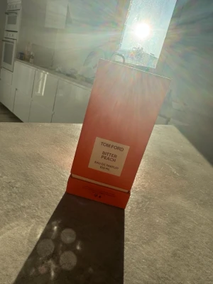 Tom Ford Bitter Peach 100ml - Tom Ford Bitter Peach Eau de Parfum i en snygg orange flaska. Volym: 100 ml. Perfekt för dig som vill sticka ut med en exklusiv doft från ett av världens mest ikoniska märken.