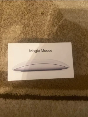 Apple Magic Mouse - Snygg och stilren Apple Magic Mouse i vitt. Pekytan möjliggör smidig scroll och gester. Kommer i originalkartong och ser ut att vara i mycket gott skick utan synliga repor eller skador. Perfekt tillbehör för Mac-användare som vill ha en trådlös och elegant mus.