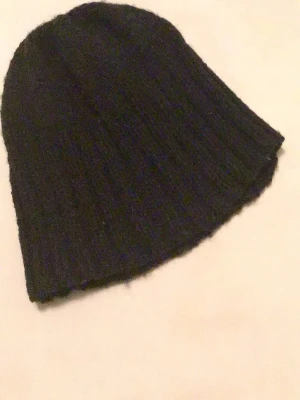Svart stickad mössa - En enkel svart stickad mössa med ribbad struktur. 