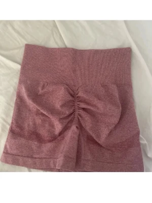 Rosa tränings shorts med scrunch  - Säljer ett par rosa träningsshorts med scrunch-detalj bak. Storlek M
