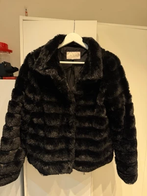 Svart pälsjacka  - Säljer en fluffig svart pälsjacka från VILA. Jackan har en klassisk krage, horisontella sömmar och är helfodrad. Perfekt för dig som vill ha en varm och snygg jacka med lite lyxig känsla. Passar till många olika stilar. Storlek 36! Pris kan diskuteras 