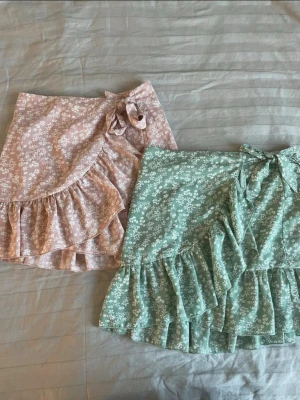 Blommig omlottkjol från SHEIN Teen - Supersöt kort omlottkjol från SHEIN Teen i blommigt mönster. Finns i ljusrosa och ljusgrönt, båda med volangkant och knyt i midjan. Perfekt för sommarens alla dagar och ger en riktigt fräsch vibe. Ta gärna emot bud och frågor 😊💕båda ingår i priset 