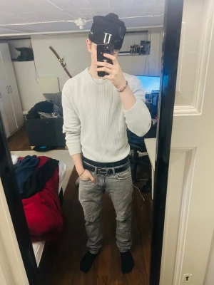 Ljusgrå stickad tröja  - Säljer en stilren ljusgrå stickad tröja från H&M. Tröjan har rund hals, ribbade muddar och är långärmad. Perfekt för lager-på-lager och passar till både jeans och chinos. Enkel och clean look som funkar året runt.