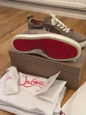 Christian Louboutin Louis Junior Low-Top sneakers - Säljer ett par beiga sneakers från Christian Louboutin i mocka med vita snören och den ikoniska röda sulan. Sparsamt använda under sommaren 2025 och inget mer sen dess. Kommer inte användning nu för tiden. Köptes i Italien från outlet. Hittade tyvärr inte kvitto, därav priset! Möts endast upp (Stockholm)! 