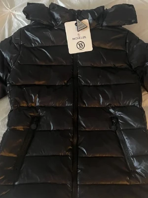 Svart Moncler  - Moncler Bady svart. Storlek 0/XS använd fåtal gånger under förra vinter så super bra skick. Köpt här på plick och då var den helt ny. Men äkthets bevis finns. (Skråma finns på dragkedjans dragare) därför jag säljer så billigt men det syns inte. Annars utöver det så finns det inte några hål eller något annat fel på jackan. 