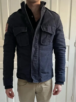 Mörkblå teddyjacka Polo Ralph lauren  - Säljer en mörkblå teddyjacka från Polo Jeans Company (Ralph Lauren) med mjukt teddyfoder, två stora bröstfickor och amerikansk flaggpatch på ärmen. Jackan har dragkedja och hög krage, perfekt för kyliga dagar. Klassisk och stilren modell. Hör av er vid frågor 😉pris kan diskuteras🙌🙌