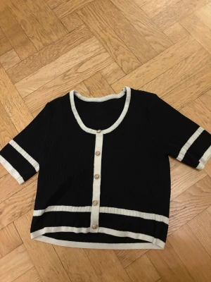 Svartvit ribbad kofta med knappar - Tröja med knappar. Storlek s-m
