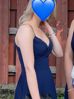 Mörkblå balklänning  - Superfin mörkblå balklänning från TFNC london, använd 1 gång så inga tecken på slitage, har för mig att denne i storlek XS           Nypris 1000kr                                                      Jag är 165 och den är för lång för mig 