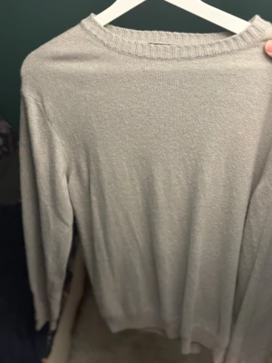 Biege stickad tröja Oscar Jacobson - Säljer en stilren biege stickad tröja från Oscar Jacobson i storlek M. Tröjan har rund halsringning med ribbad kant och långa ärmar. Tröjan har kanske använts någon enstaka gång.