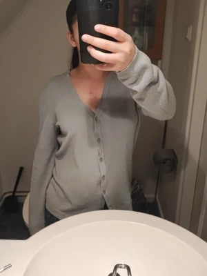 Ljusgrön kofta med knappar - En enkel ljusgrön kofta med v-ringning och knappar. Den är väldigt stor, så kanske är den en L eftersom det fanns ingen storlek när jag köpte den. 