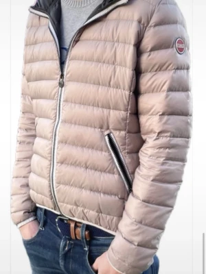 Grå pufferjacka från Colmar - Lätt och stilren jacka i beige Snygg quiltad jacka i ljusbeige färg. Lätt och bekväm med huva, dragkedja framtill och praktiska fickor med dragkedja. Passar lika bra till vardag som till mer uppklädd stil. Kan självklar skicka fler bilder om det önskas. Finns någon fläck på framsidan men går säkert att få bort i tvätt har bara inte haft tid att göra det. Unisex.
